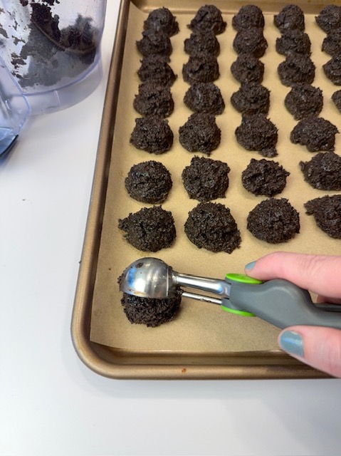 Scooping oreo balls onto cookie sheet