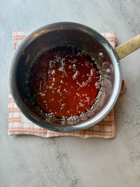 Homemade honey cough drop syrup cooling in saucepan