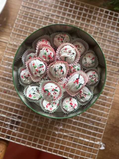 Dipped oreo balls with sprinkles in Christmas tin