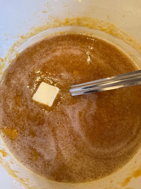 Adding butter and pectin to pear jam