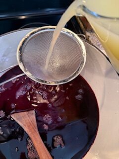 straining lime juice into dutch oven