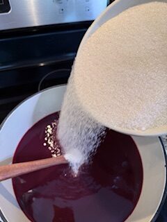 Pouring sugar into cherry lime mixture