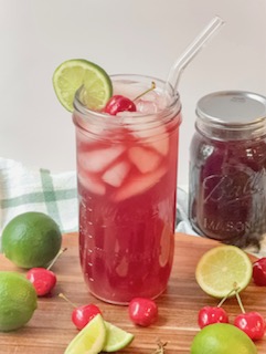 Cherry Limemade on wood board with cherries and limes