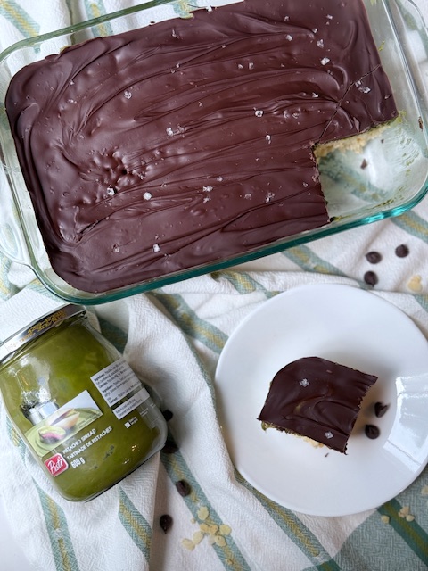 Rice krispie treats topped with pistachio cream and melted chocolate