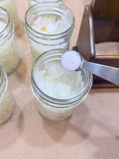 pouring salt into jars with diced onions