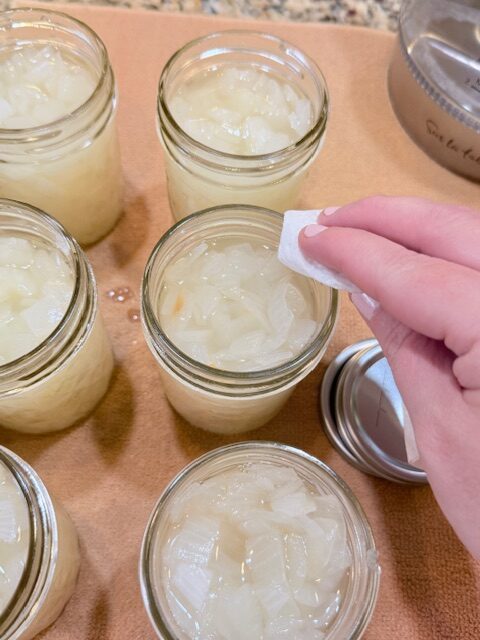 wiping rims of jars with paper towel