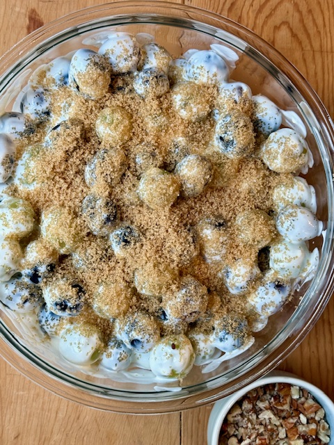 Grape Salad topped with brown sugar in glass bowl