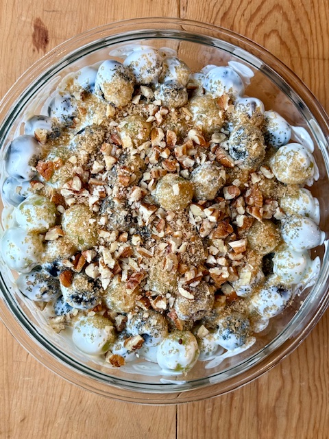 Grape Salad topped with brown sugar and pecans in glass bowl
