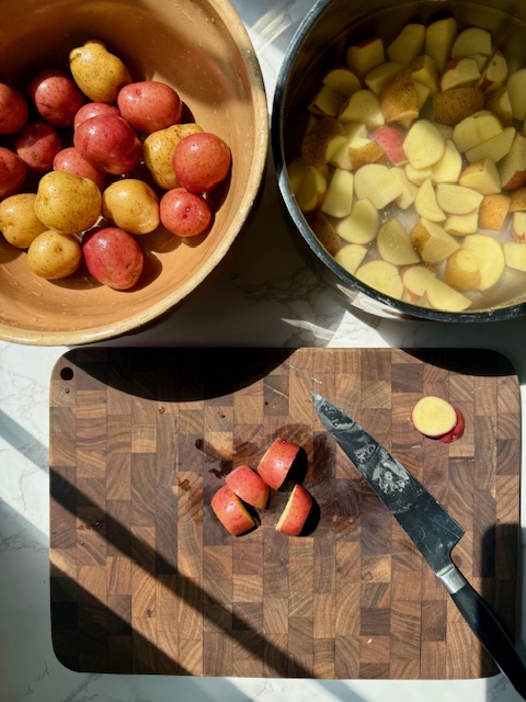 Cutting Baby Potatoes on wood cutting board