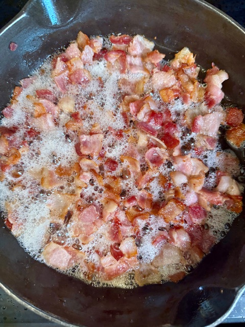 bacon frying in cast iron skillet