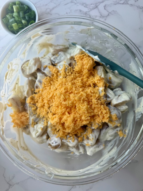 Adding cheese to potato salad