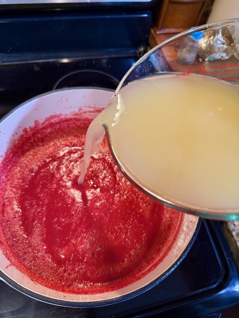 pouring lemon concentrate into strawberry puree