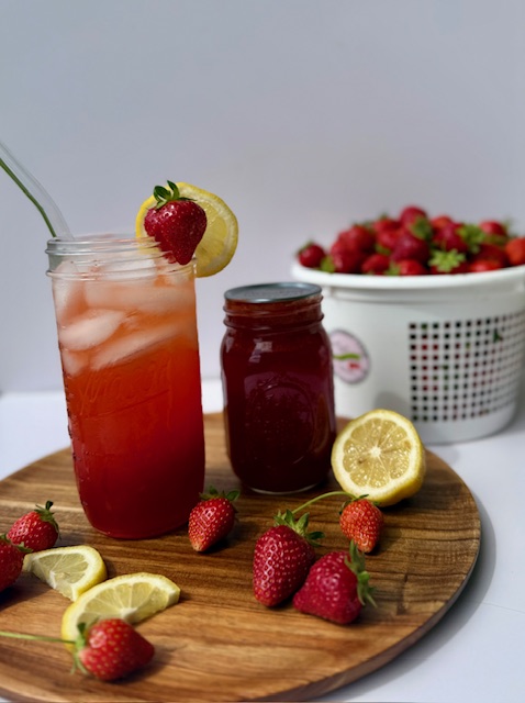 Strawberry Lemonade Concentrate in mason jar with fresh strawberries and lemons