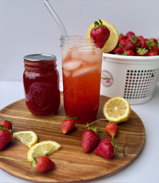 Strawberry Lemonade Concentrate in mason jar with fresh strawberries and lemons