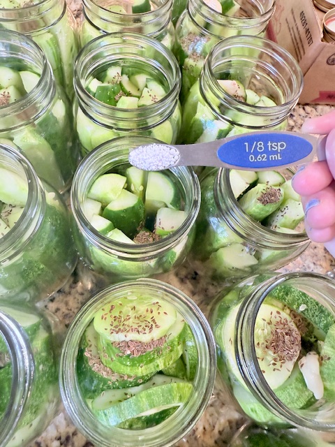 pouring pickle crisp into mason jars