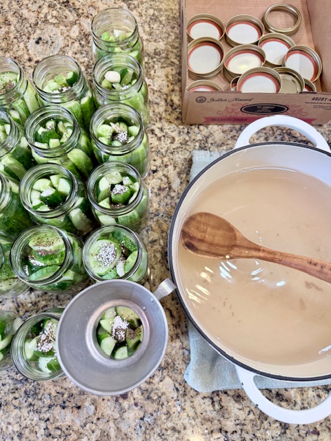 ladling hot brine onto pickles